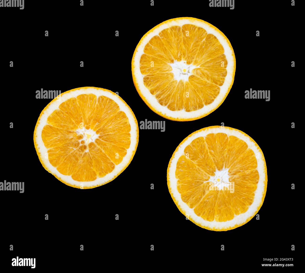 Tres rodajas naranjas sobre fondo negro Foto de stock