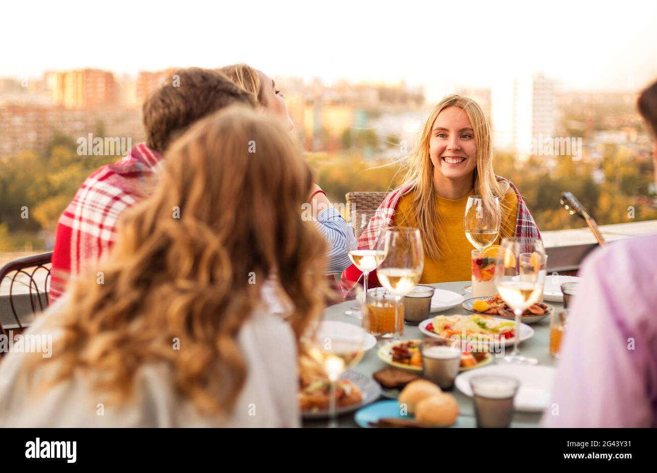 Amigos alegres bebiendo vino blanco durante la fiesta en el tejado  Fotografía de stock - Alamy