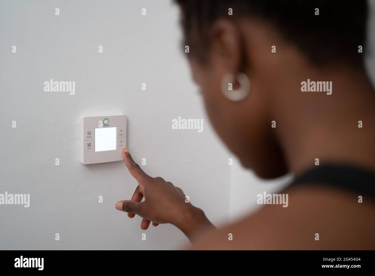 mujer negra joven que utiliza la automatización doméstica Foto de stock