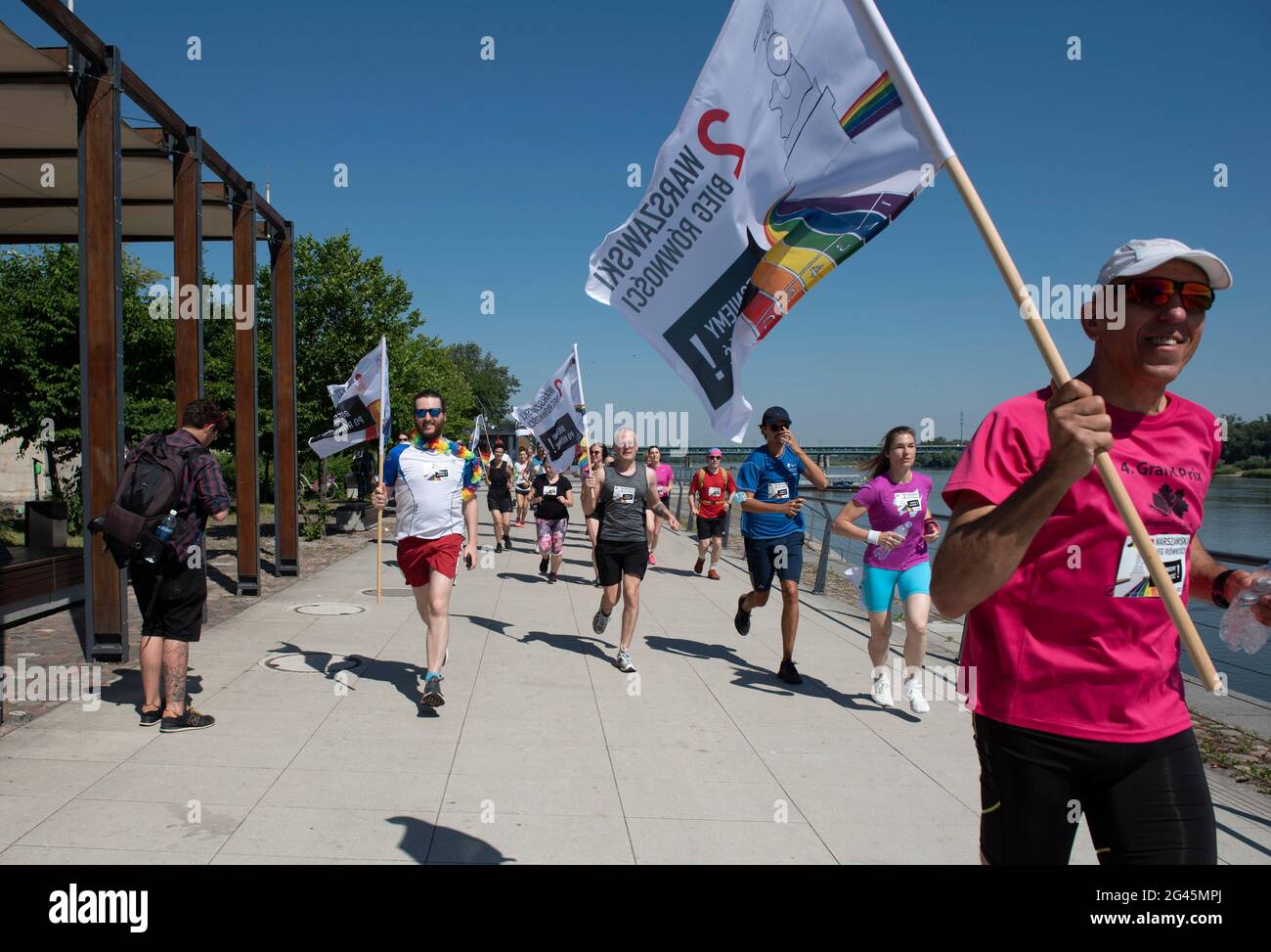 Varsovia, Varsovia, Polonia. 19th de junio de 2021. Los participantes del Equidad Jog tienen banderas mientras se ejecutan el 19 de junio de 2021 en Varsovia, Polonia. Una docena de personas participaron en el Jog de Igualdad 2nd, organizado por el grupo activista Homokomando, que consiste en una ruta de 5 km y tiene lugar antes del Desfile del Orgullo de Varsovia. Crédito: Aleksander Kalka/ZUMA Wire/Alamy Live News Foto de stock