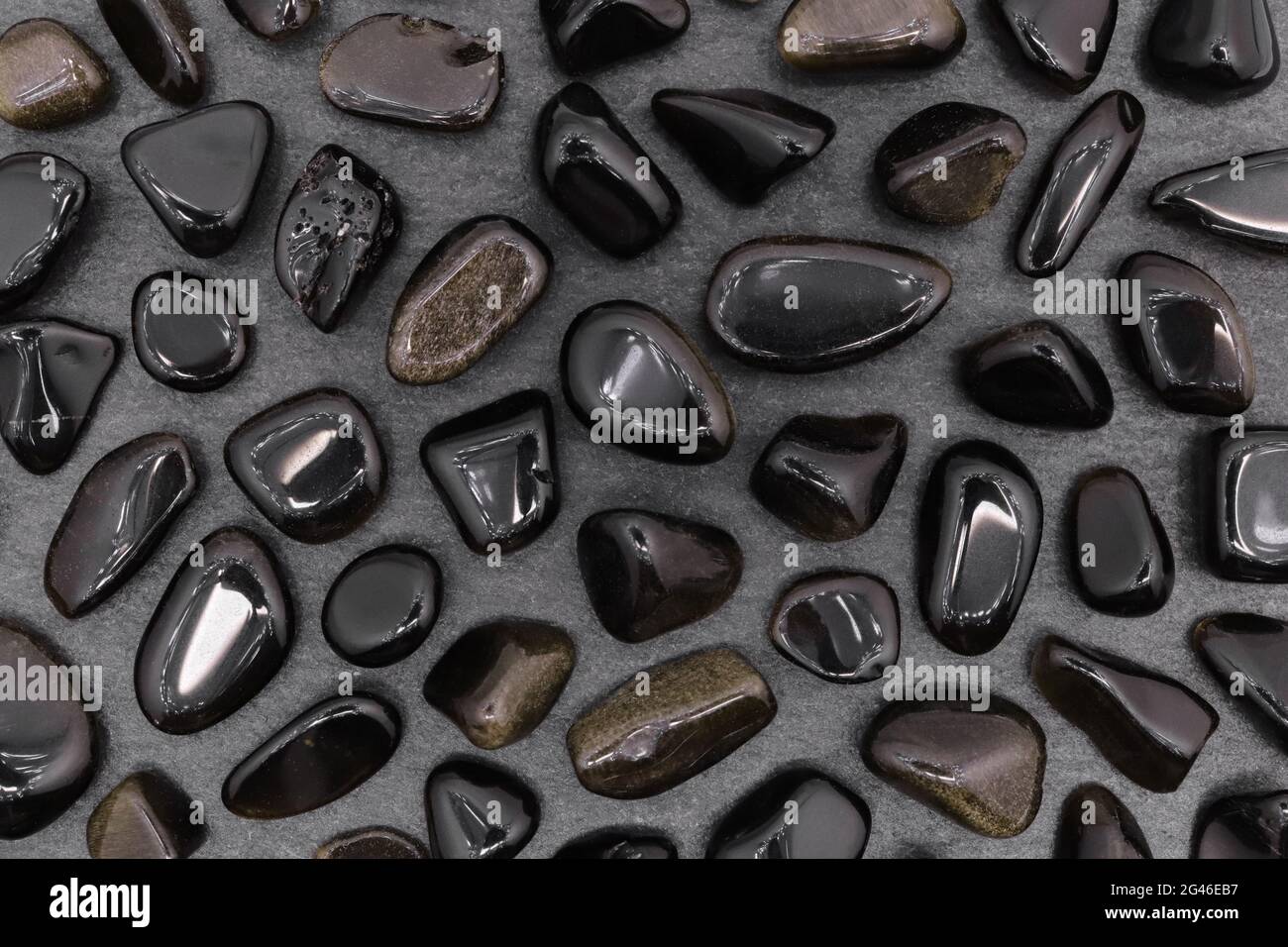 Joya rara de obsidiana de oro sobre textura de piedra negra