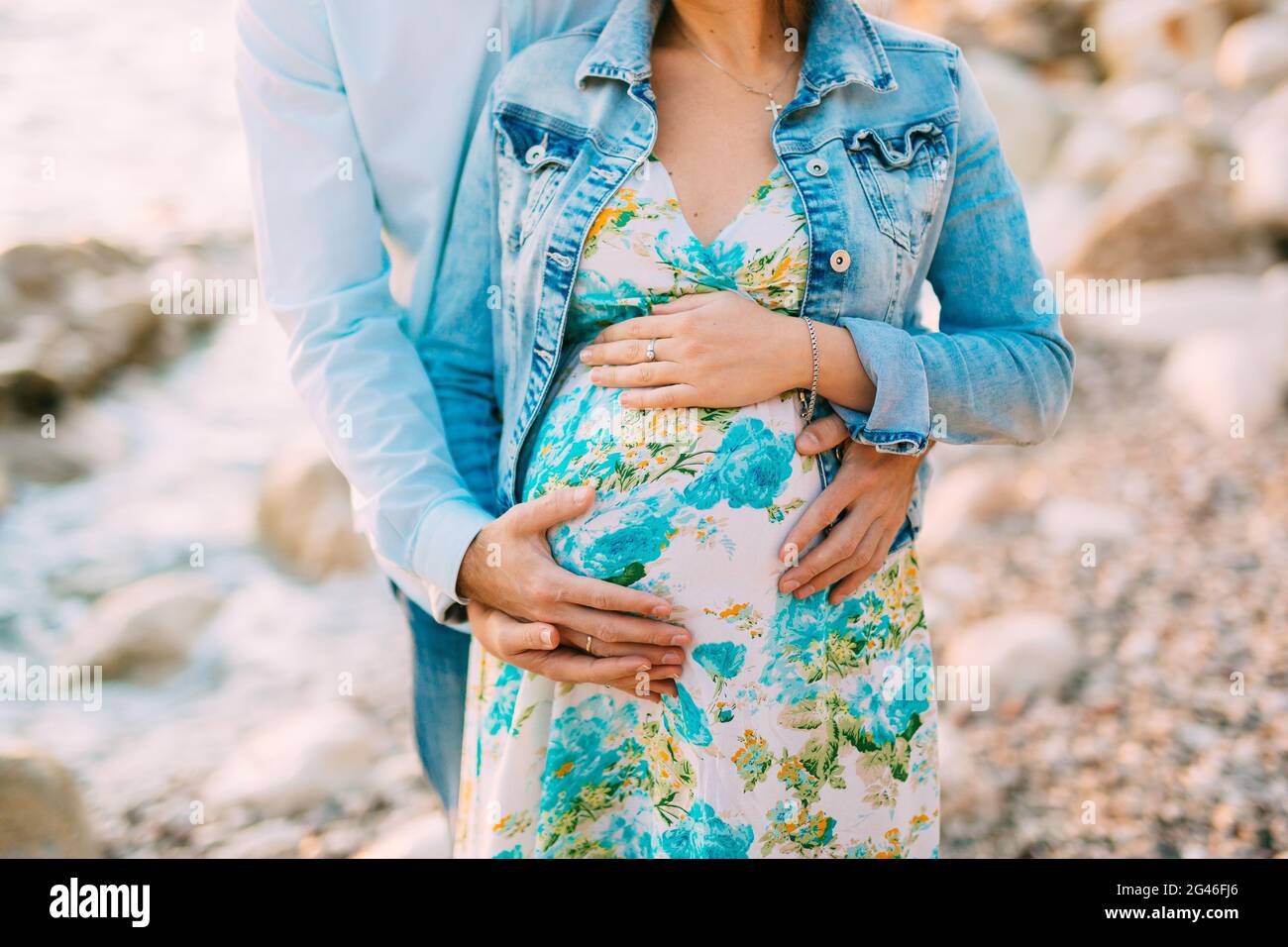 Mujer embarazada sujetando el vientre con las manos Foto de stock