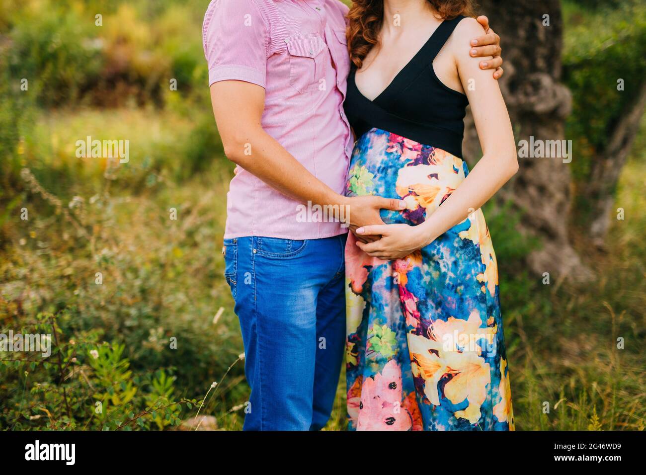 Mujer embarazada sujetando el vientre con las manos Foto de stock