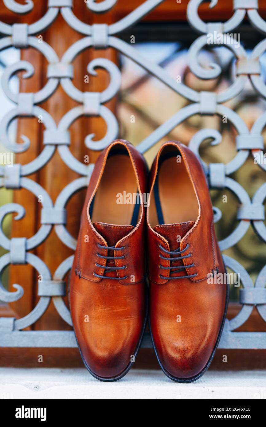 Nuevos zapatos marrones para hombre junto a la ventana con barras de metal  con poca profundidad de campo Fotografía de stock - Alamy
