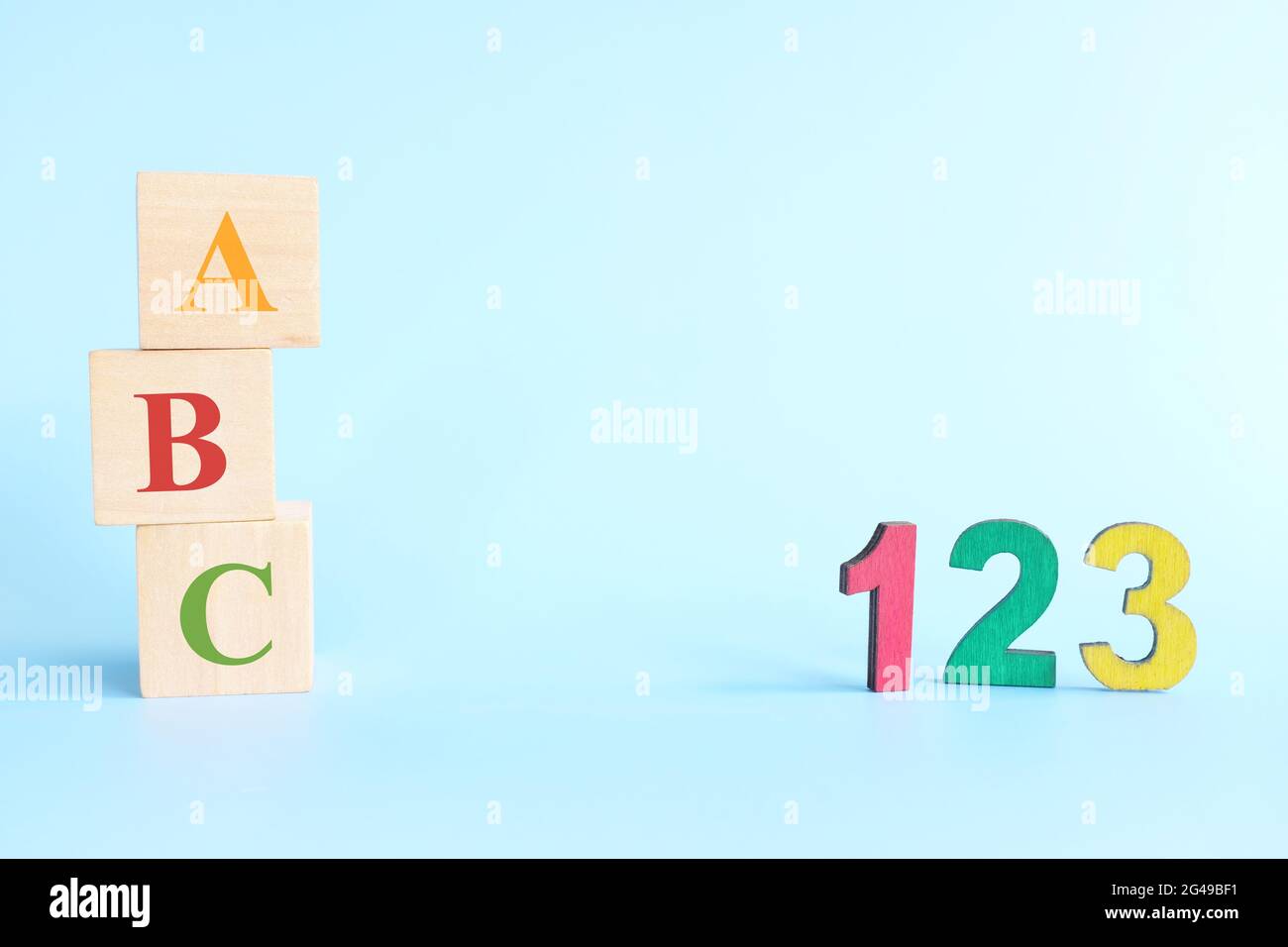 123 números coloridos y letras abc alfabeto en bloques de madera en fondo azul con espacio de copia. Principio del concepto de conteo de aprendizaje de niños o niñas. Foto de stock