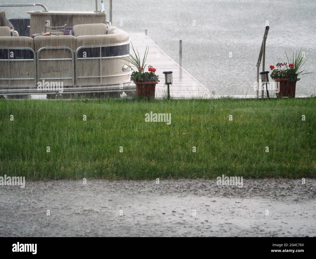 Un día lluvioso del lago con lluvia que vierte un barco que muestra Foto de stock