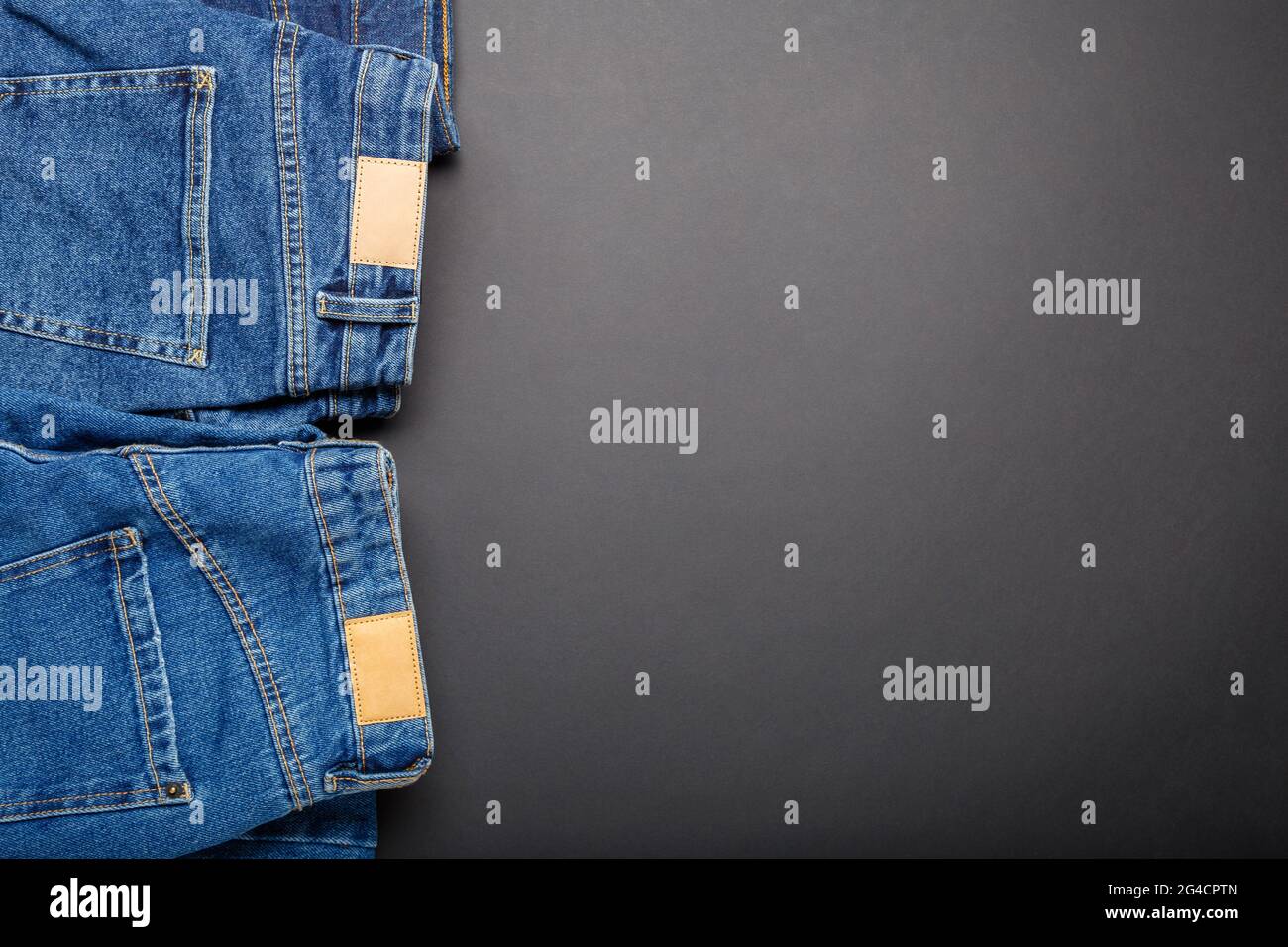 burlarse de Específico Consistente Jeans azules clásicos. Pantalones sport ropa jeans azules con etiquetas de  cuero blanco marrón sobre fondo negro con espacio para copias. Vista  superior Fotografía de stock - Alamy