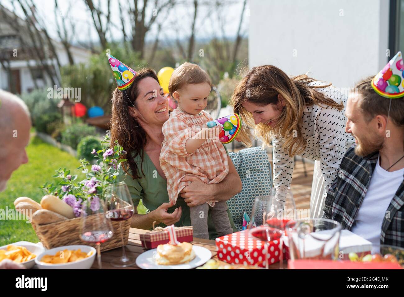 Feliz familia de varias generaciones al aire libre en el jardín en casa, fiesta de cumpleaños. Foto de stock