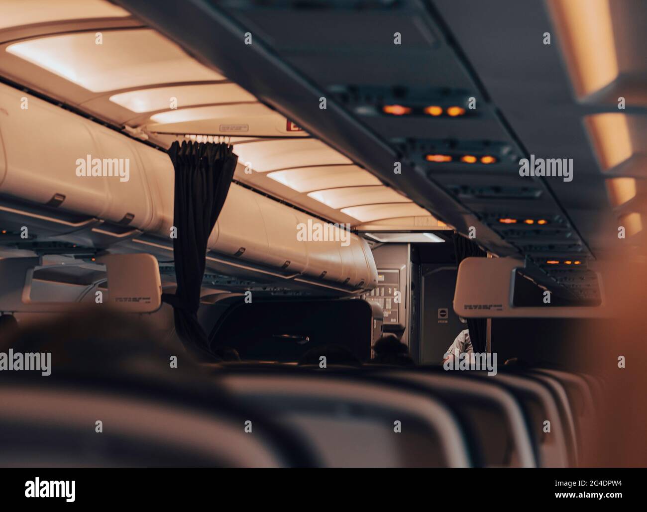 Interior de asientos vacíos en un avión. Sólo unos pocos pasajeros se sientan en el avión vacío durante un vuelo en encierro y las prohibiciones de viajar por el virus de la corona. Foto de stock