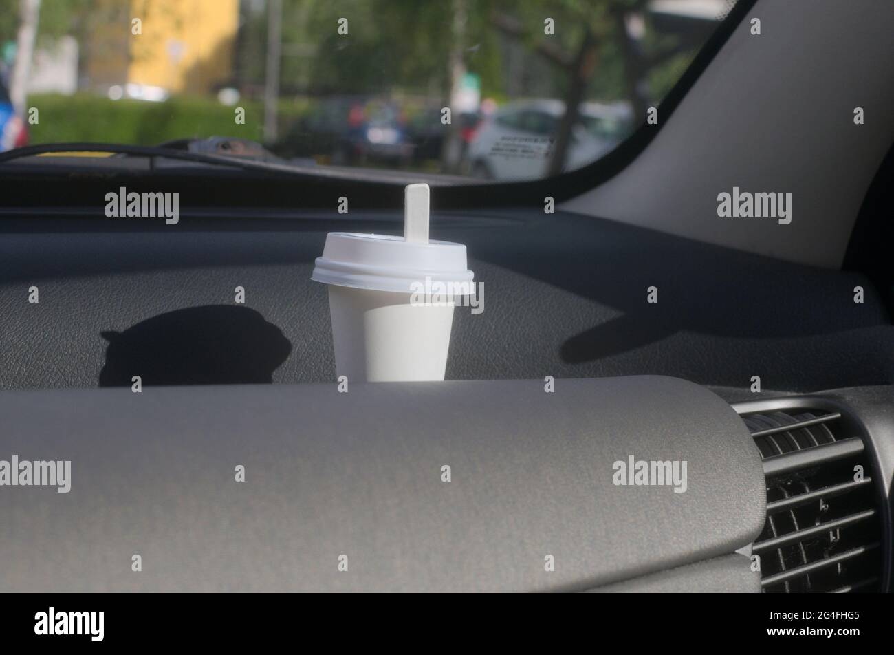 taza de café desechable en el salpicadero del coche Foto de stock