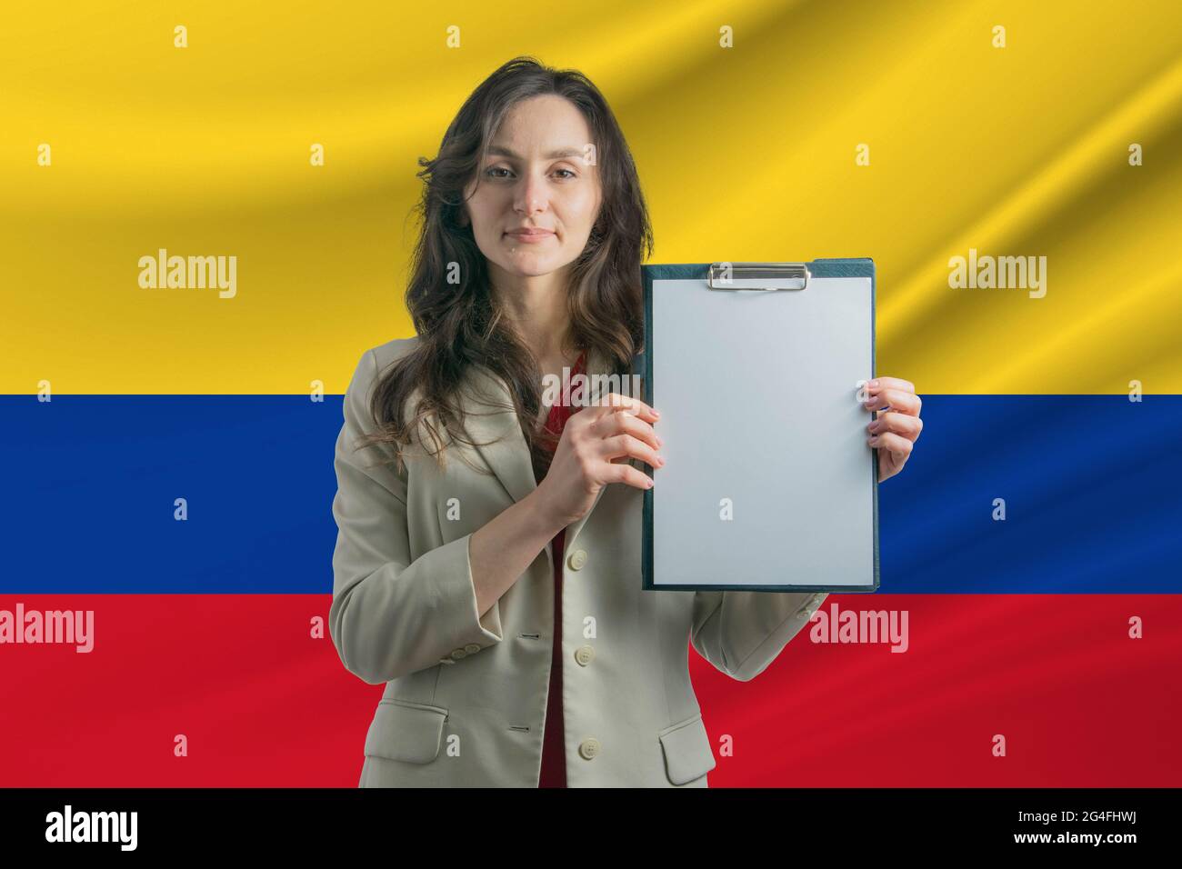 Estudiar en Colombia Hermosa mujer sosteniendo una hoja de papel en sus  manos. Niña en el fondo de la bandera de Colombia Fotografía de stock -  Alamy