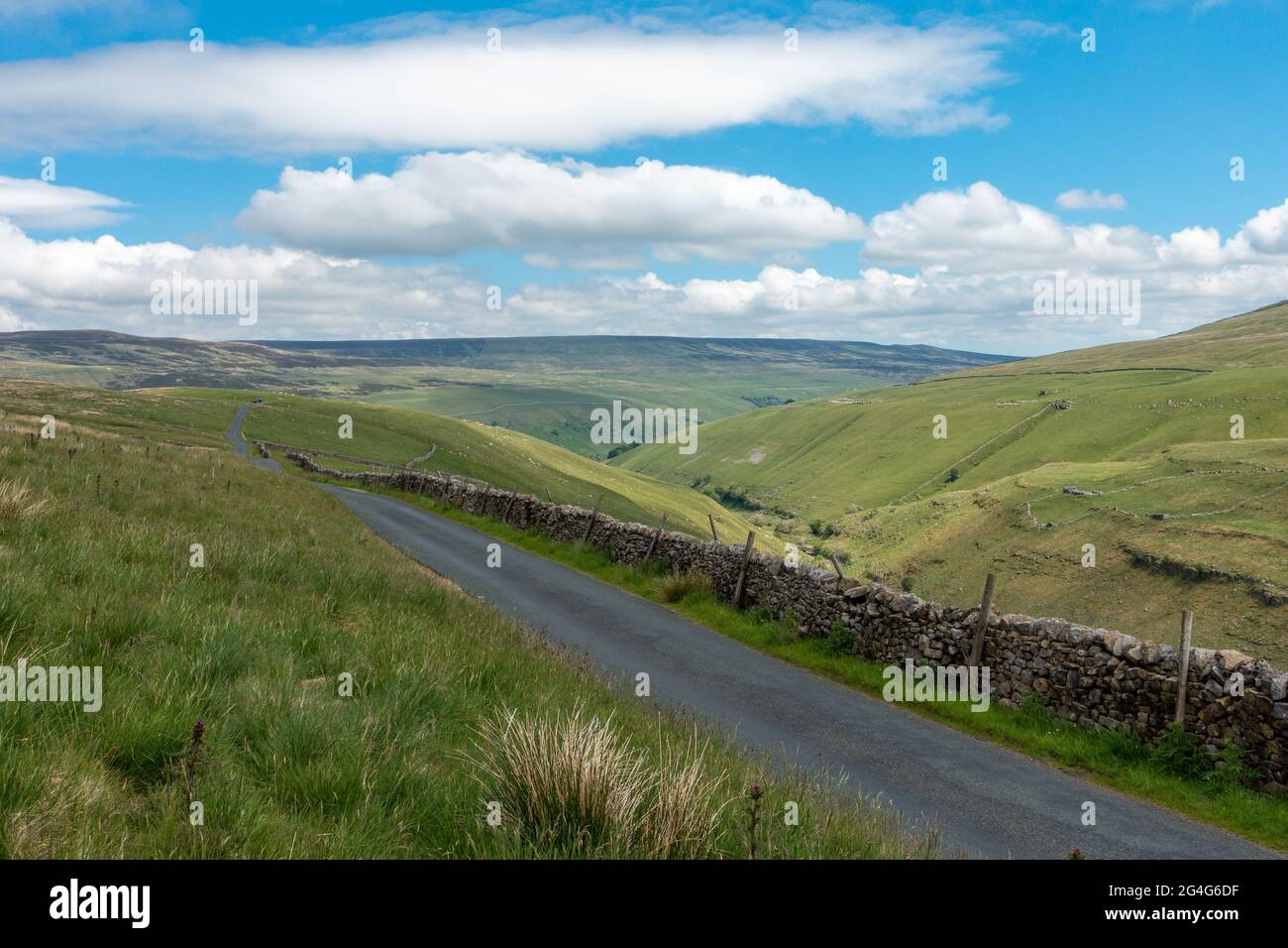 Impresionante paisaje de Yorkshire Dales de una tranquila carretera rural junto a Pen-y-gante Gill Beck mirando hacia Halton Gill en Littondale, Reino Unido Foto de stock