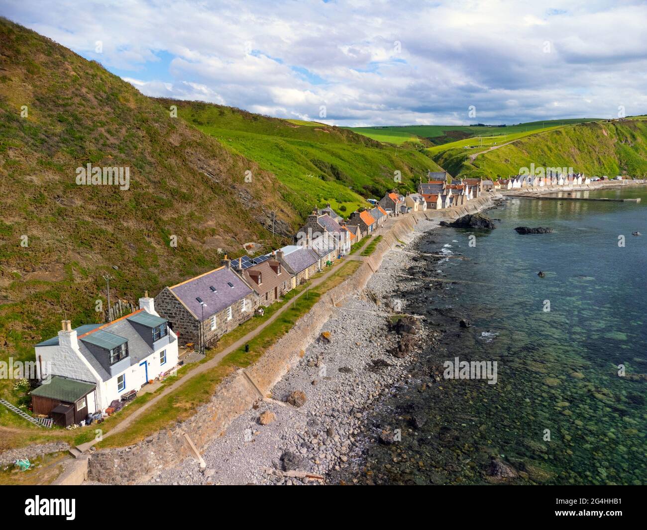 Vista aérea desde el drone de las casas en el pueblo de Crovie en la costa de Moray Firth en Aberdeenshire, Escocia, Reino Unido Foto de stock