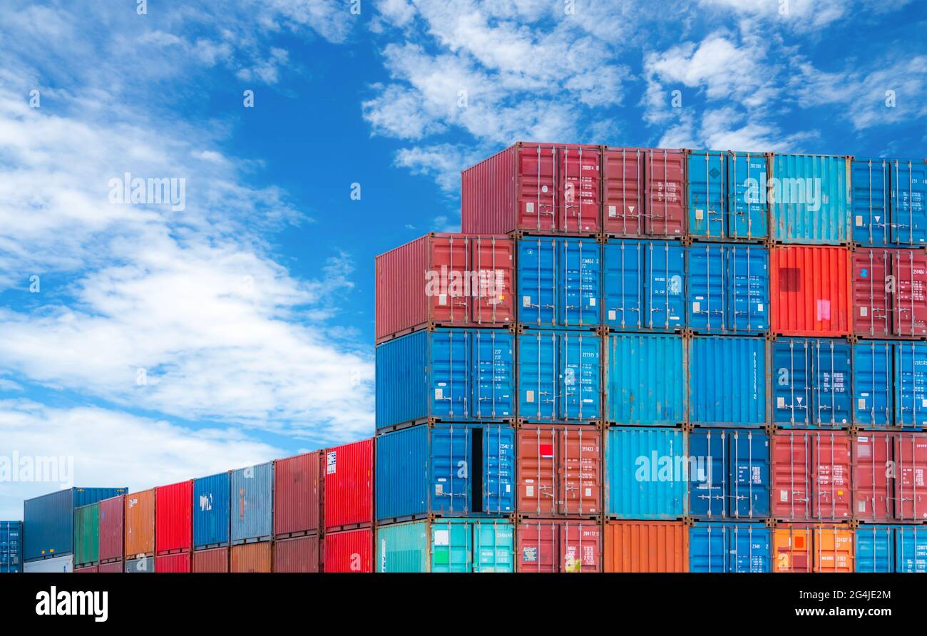 Contenedor logístico rojo y azul contra el cielo azul. Negocio de carga y transporte marítimo. Buque contenedor para logística de importación y exportación. Industria logística. Foto de stock