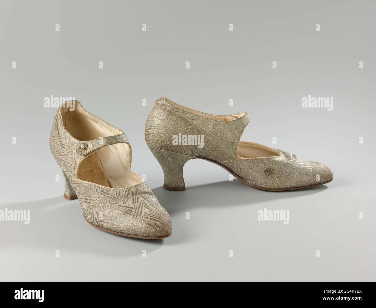 Zapatos para mujer de brocado de plata con correa para el tobillo. Modelo:  Punta redondeada, una basura y dos hojas laterales. El corte de la portada  se extiende hasta la mitad