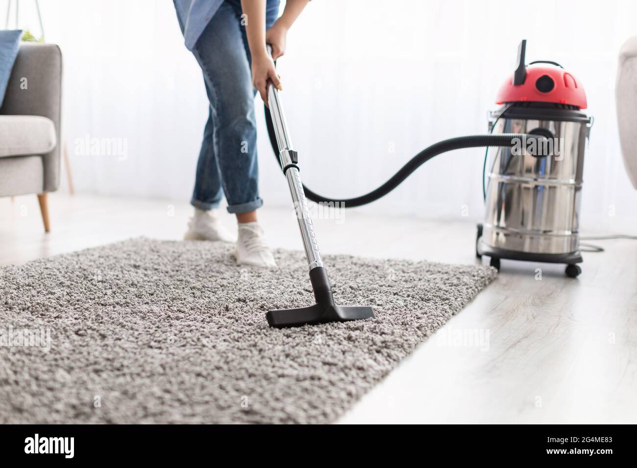 Parte baja de la moqueta de limpieza de la mujer con aspiradora Fotografía  de stock - Alamy