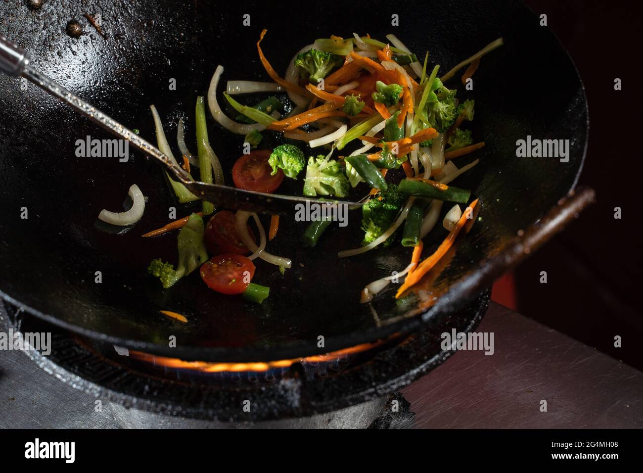 Freír verduras en una sartén wok cebollas, brócoli, tomates cherry,  zanahoria, espárragos Fotografía de stock - Alamy