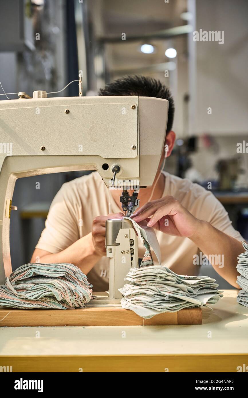 Detalle del trabajador que aplica pegamento a la suela de zapatos en una  línea de producción de la fábrica china de zapatos Fotografía de stock -  Alamy