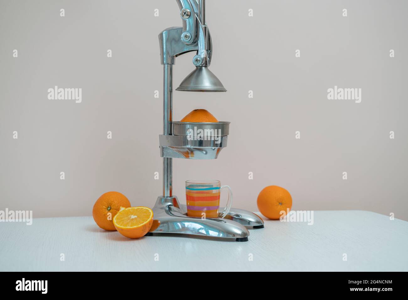 exprimidor de prensa manual de metal de acero con naranjas cortadas y  cristal sobre la mesa de la cocina en casa Fotografía de stock - Alamy