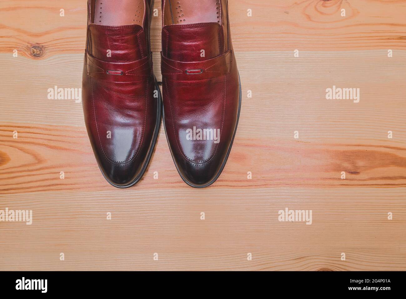 Zapatos para hombre hechos de cuero natural marrón rojo se levantan en un  espacio de copia de fondo de suelo de madera Fotografía de stock - Alamy