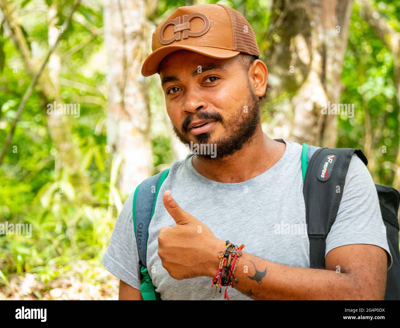 Minca, Magdalena, Colombia - 19 2021 de mayo: El hombre latino de barba marrón lleva una gorra y está en el bosque rodeado de mucha naturaleza Foto de stock