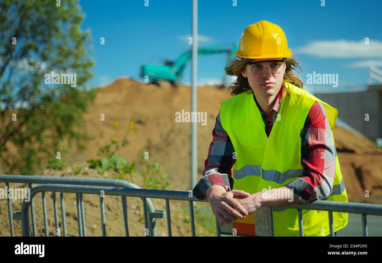 Hombre trabajador en casco y chaqueta de alta visibilidad. Foto de stock