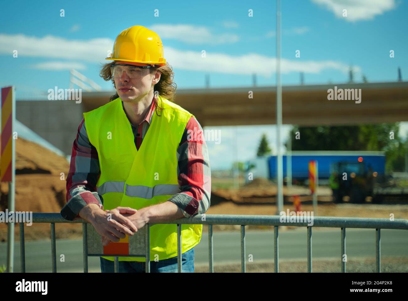 Hombre trabajador en casco y chaqueta de alta visibilidad. Foto de stock