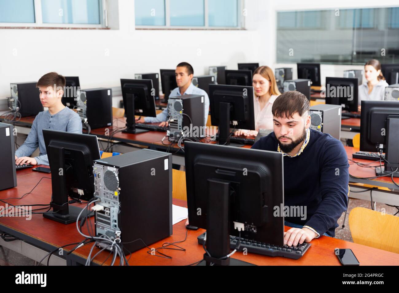Grupo de personas que aprenden a usar las computadoras en el aula