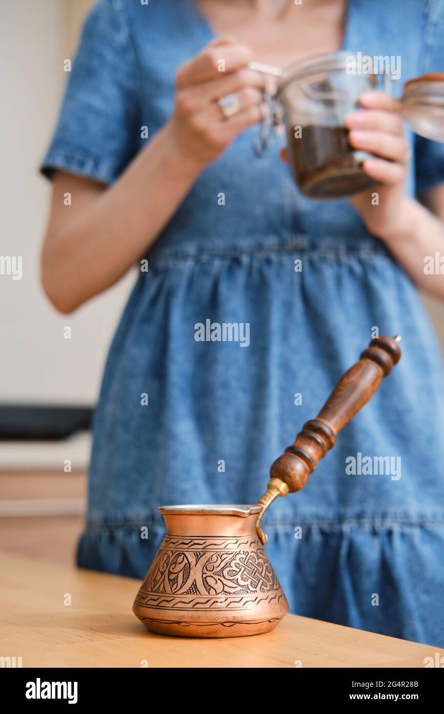 Mujer irreconocible que hace café turco, sostiene una jarra con granos de  café groung (enfoque en primer plano Fotografía de stock - Alamy