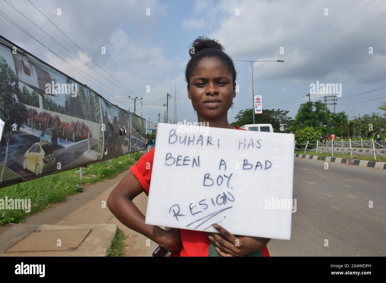 Una manifestante hembra exhibiendo su cartel mientras los manifestantes barricaban la carretera principal que conectaba Lagos y otras partes del país en el estado de Alausa, durante una manifestación pacífica contra la brutalidad policial. Nigeria. Foto de stock