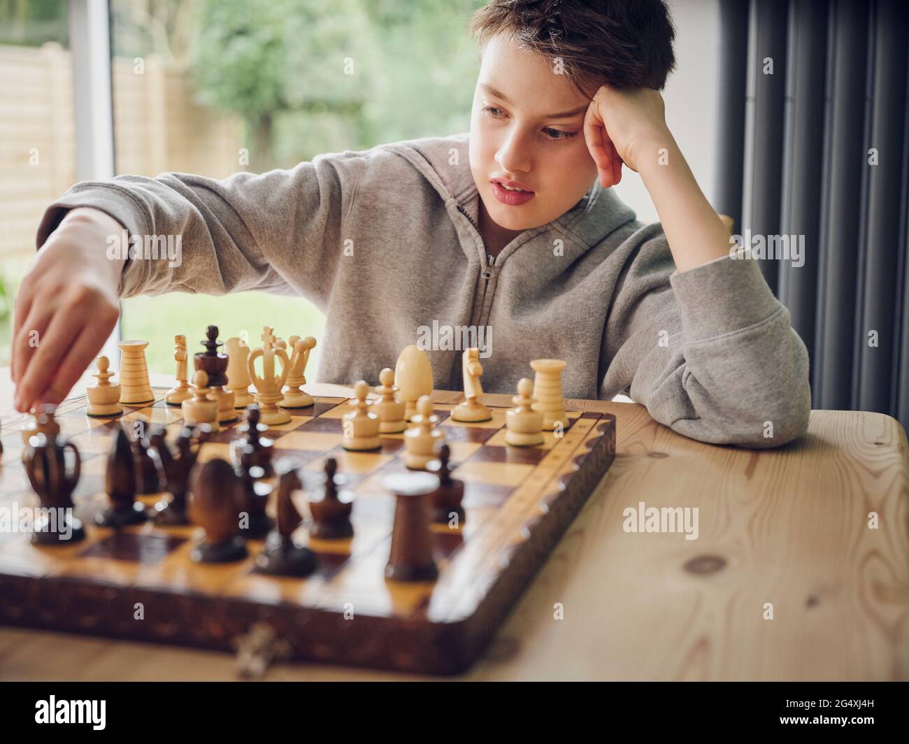 Niño inteligente jugando al ajedrez en casa Foto de stock