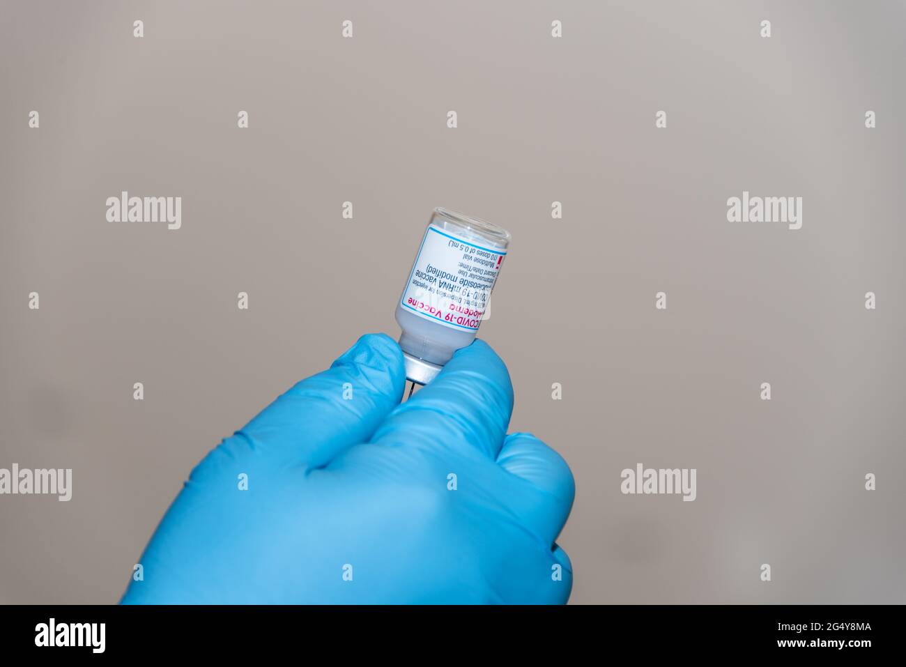Flasche mit Corona-Impfstoff von Moderna aus denen die Impfdosen für die Impfung entnommen werden in der Hand eines Arztes Foto de stock