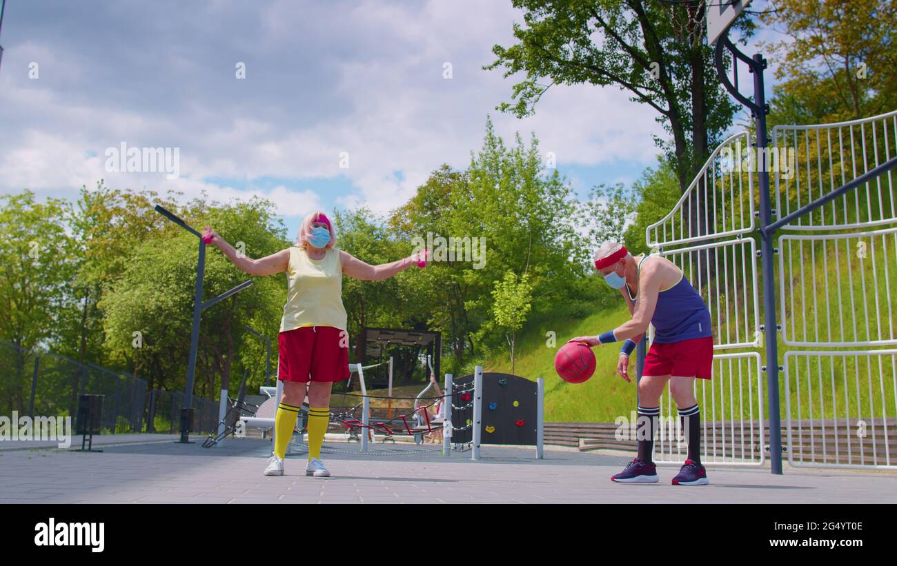 Mujer hombre mayor activa jugando al baloncesto al aire libre en