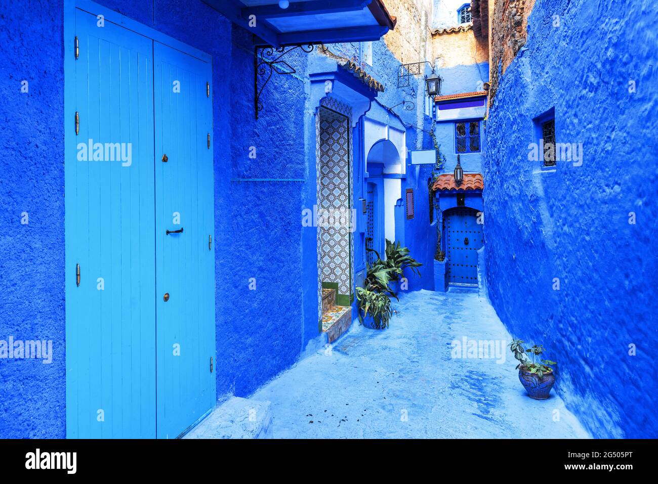 Patio estrecho con paredes tradicionales de color azul de las casas en la antigua medina de Chefchaouen. Marruecos, África del Norte Foto de stock