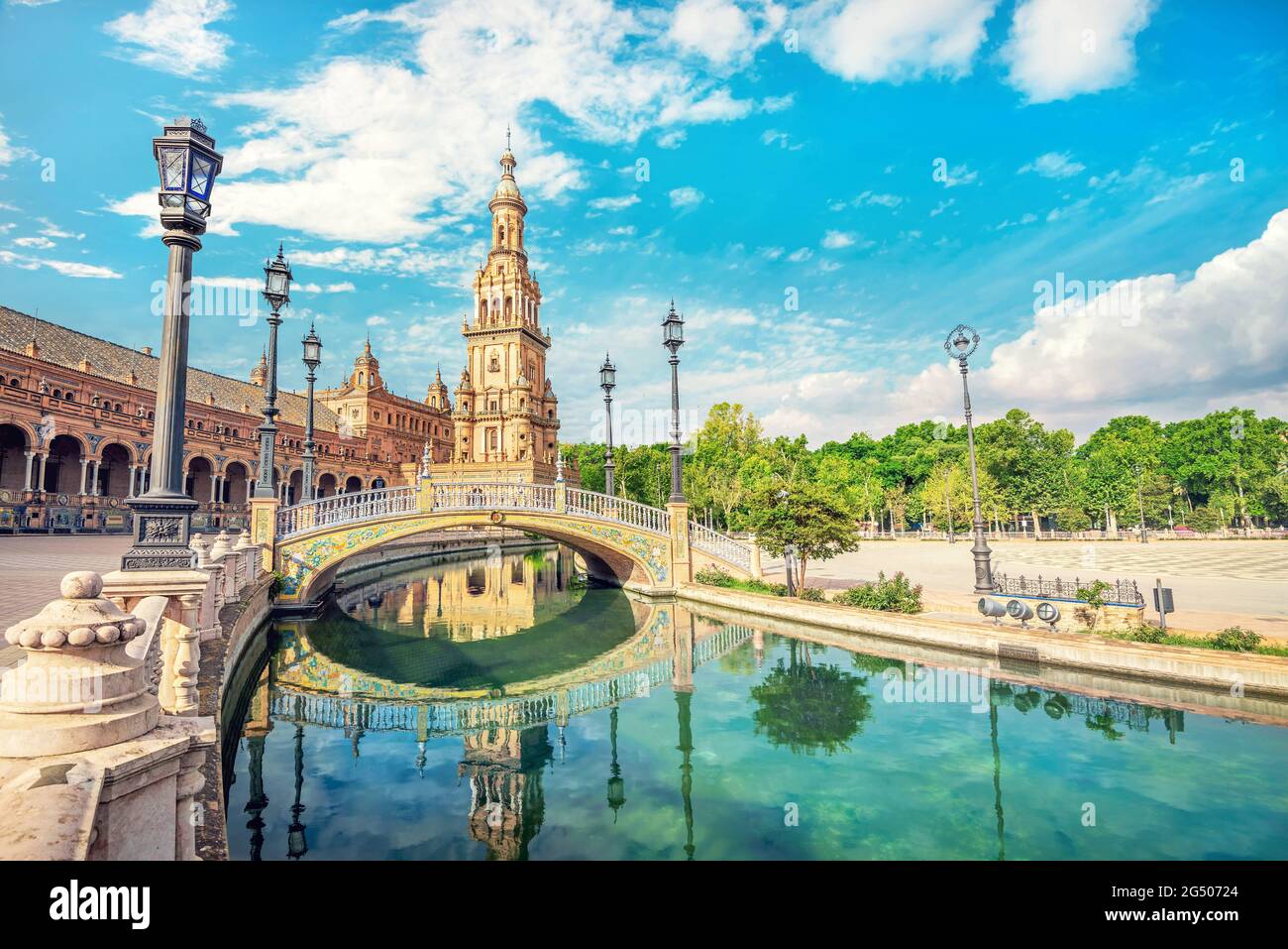 Vista panorámica con puente y reflejo en el agua de la famosa Plaza de España. Sevilla, Andalucía, España Foto de stock