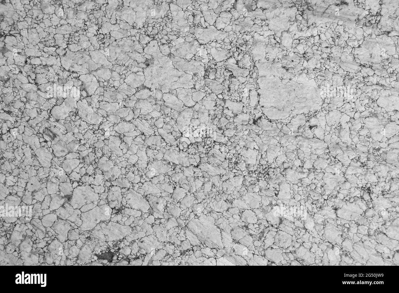 Fondo de piedra de granito antiguo molino de harina erosionada. Colores de granito blanco, gris y negro, piedra de más de cien años. Foto de stock