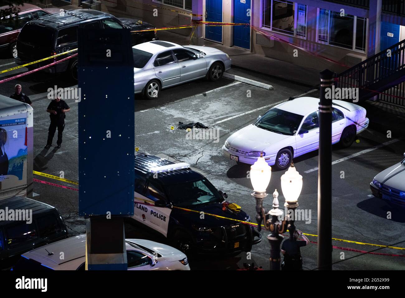 Portland, Estados Unidos. 24th de junio de 2021. Un artículo de ropa  rodeado de marcadores de evidencia se encuentra en un motel 6  estacionamiento donde un oficial de disparos tuvo lugar a