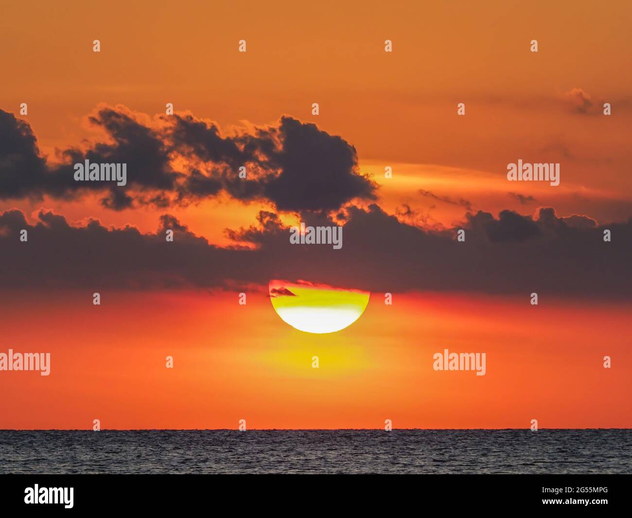 Sol en el cielo naranja al atardecer sobre el Golfo de México frente a Venecia, Florida, Estados Unidos Foto de stock