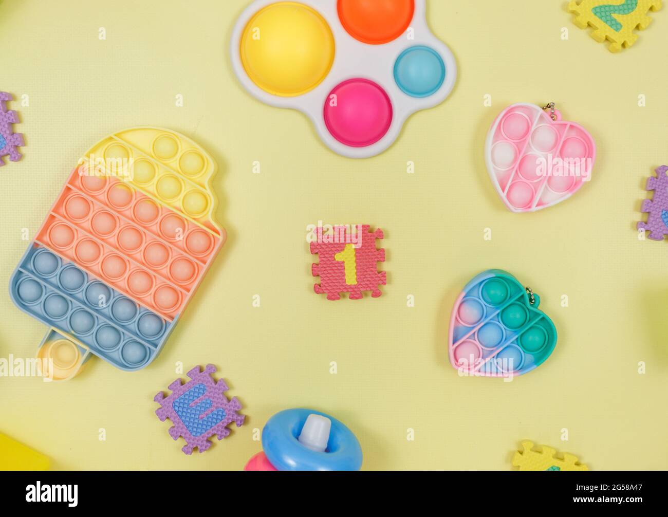 Popular silicona anti-estrés pop-it juguetes para un niño sobre fondo amarillo. Moderno relevista estrés sensorial Fidget Toy. Foto de stock