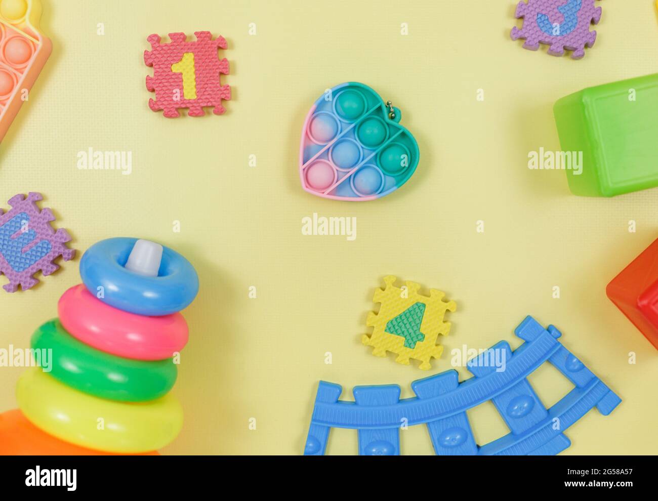 Popular silicona anti-estrés pop-it juguetes para un niño sobre fondo amarillo. Moderno relevista estrés sensorial Fidget Toy. Foto de stock