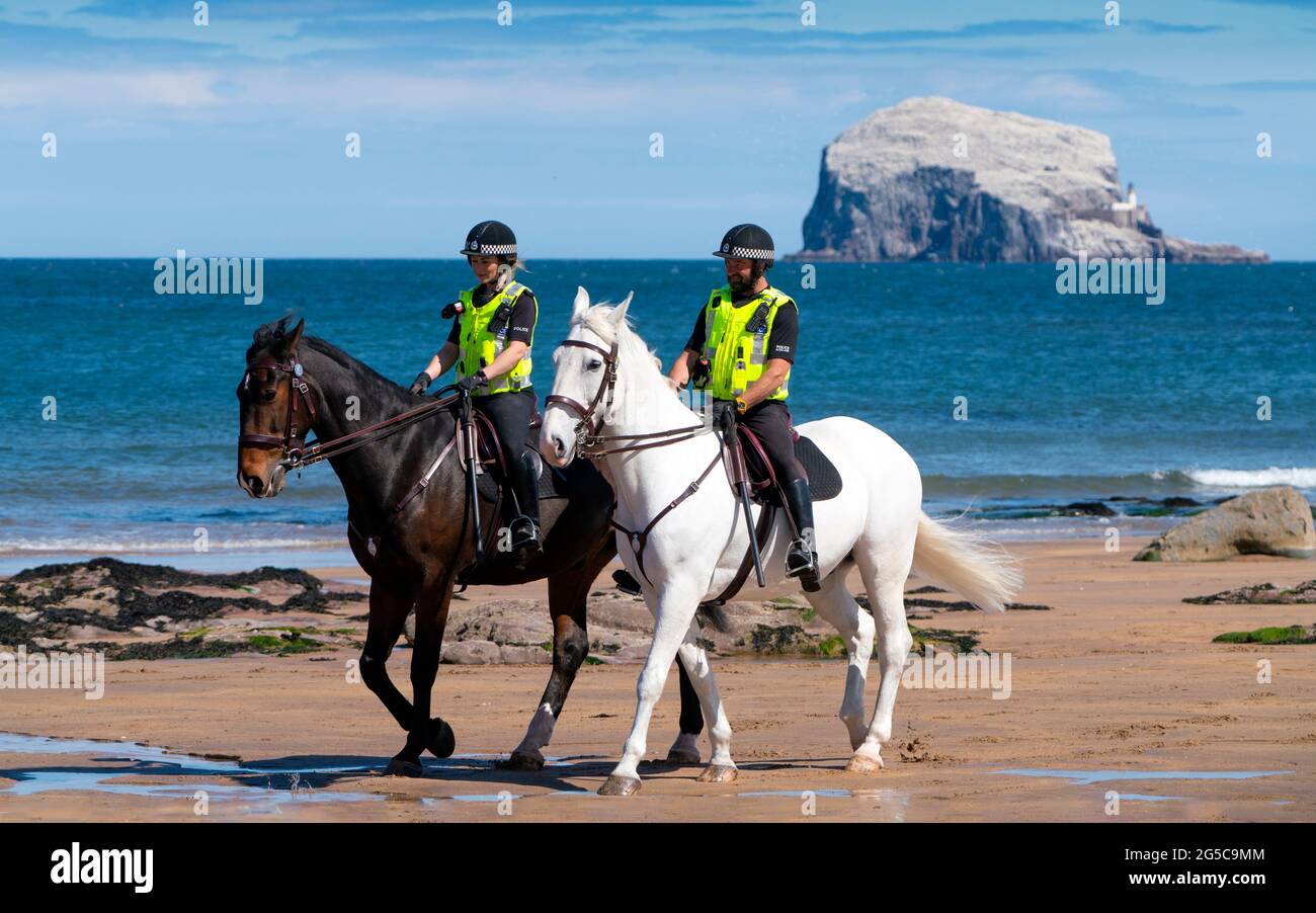 Policía montada patrullando las playas de Berwick del Norte en Lothian Oriental durante el cierre de la pandemia de Coronavirus, Escocia, Reino Unido Foto de stock