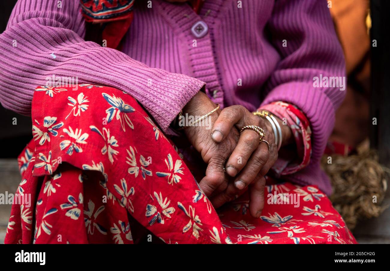 Cerca de las manos cruzadas de una abuela mayor nepalesa. Foto de stock