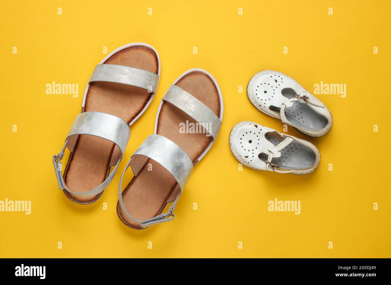 Sandalias de moda para niños y adultos sobre fondo amarillo. Vista superior  Fotografía de stock - Alamy