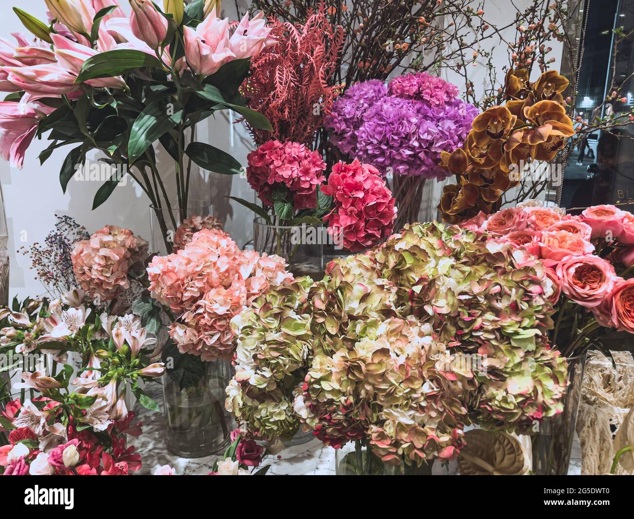 Hermosas flores de regalo en una tienda - coloridas flores naturales y rosas - regalo del día de la madre Foto de stock