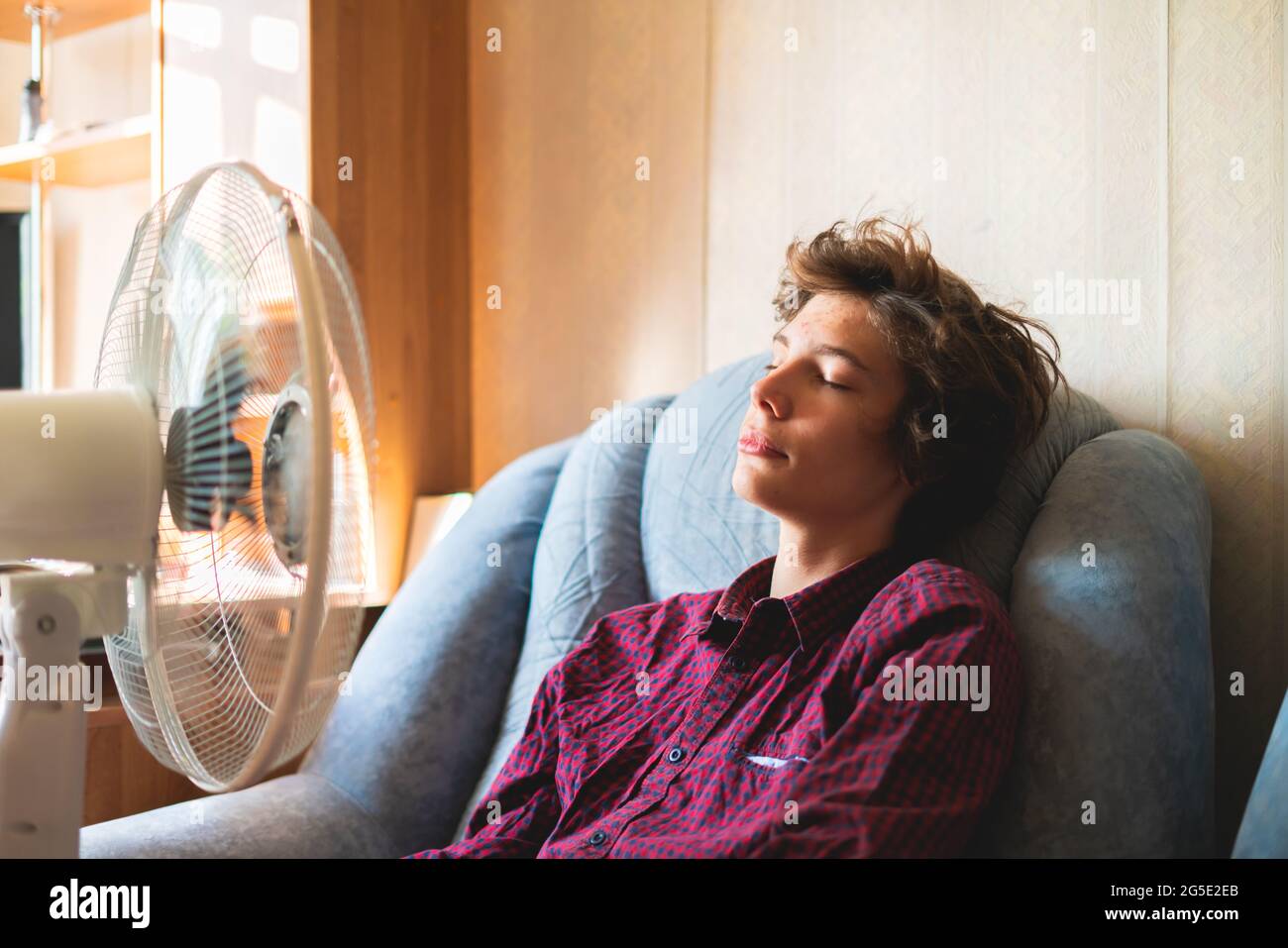 persona que disfruta del ventilador eléctrico, refrescándose la cara en  casa, durante el calor del verano Fotografía de stock - Alamy