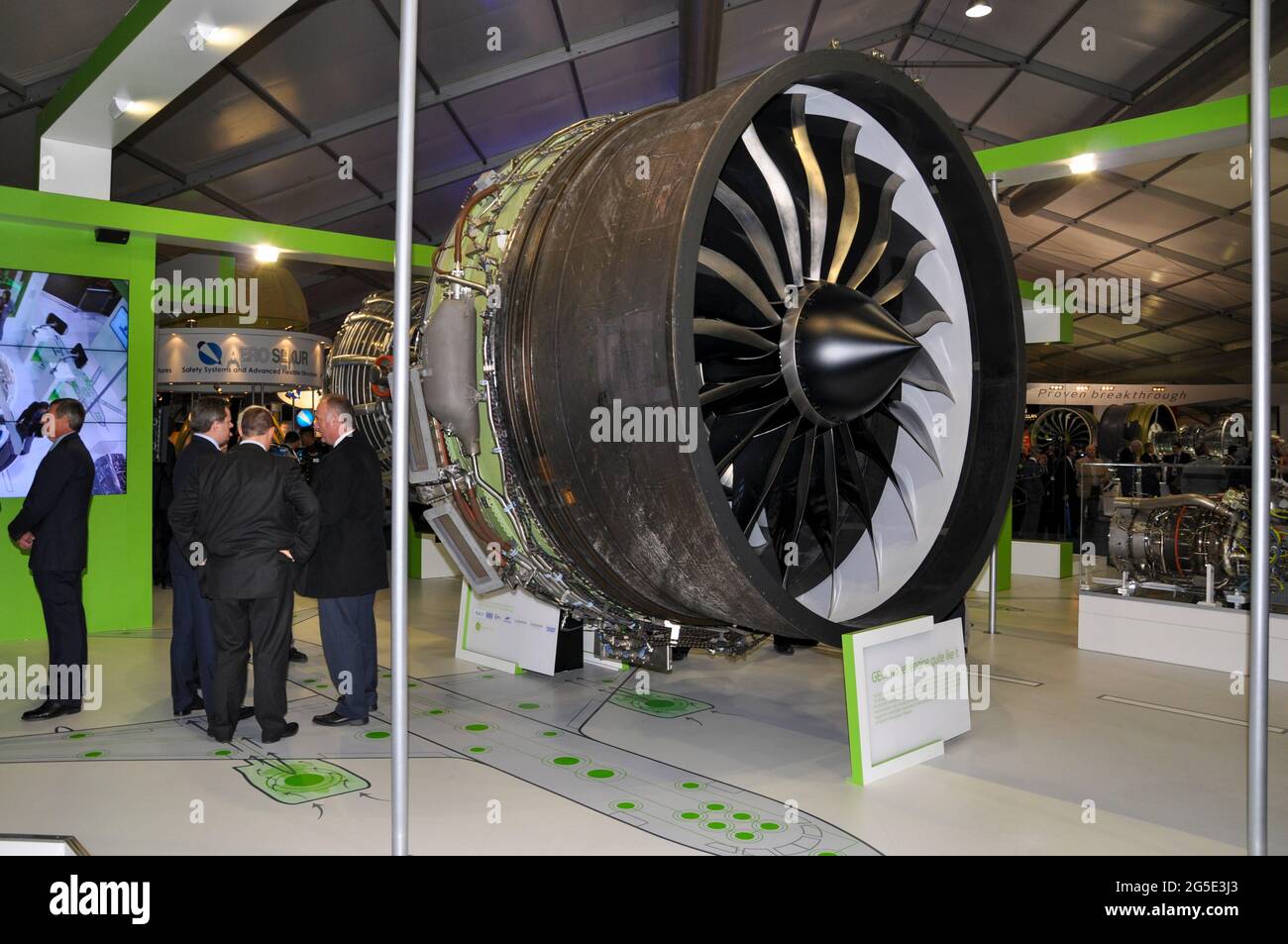 General Electric Motor GEnx turbofan en exhibición en la feria internacional de aviación de Farnborough 2012, Reino Unido. Representantes de empresas en el puesto de comercio Foto de stock