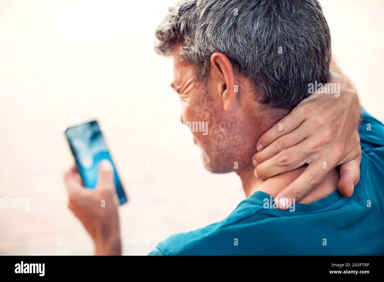 Dolor de cuello con el smartphone al aire libre. Concepto de salud, estilo de vida y tecnología Foto de stock