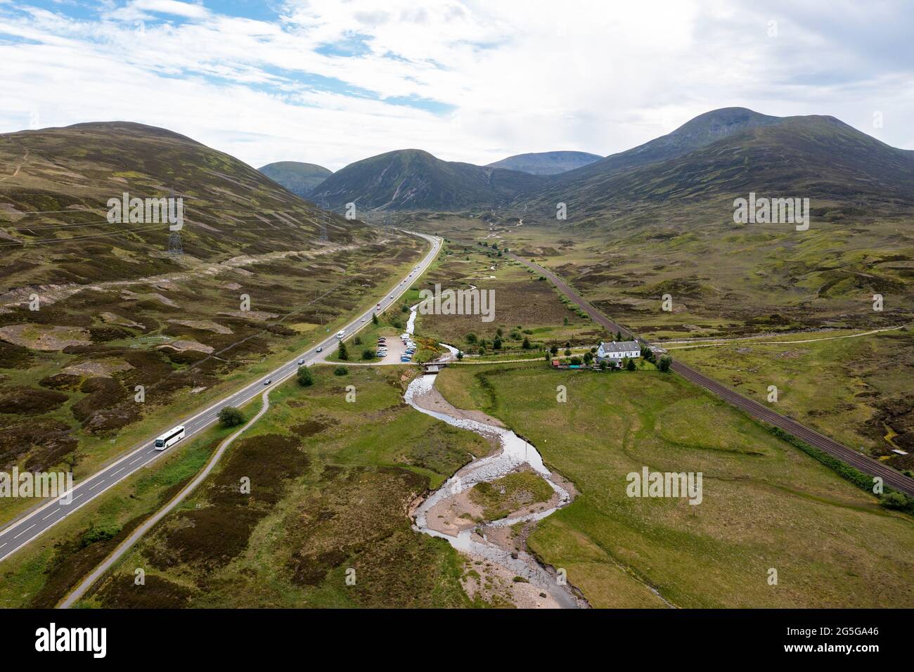 Vista aérea de la carretera principal A9 y la línea principal de ferrocarril de las tierras altas en el Puerto de Drumochter, región de Highland, Escocia, Reino Unido Foto de stock