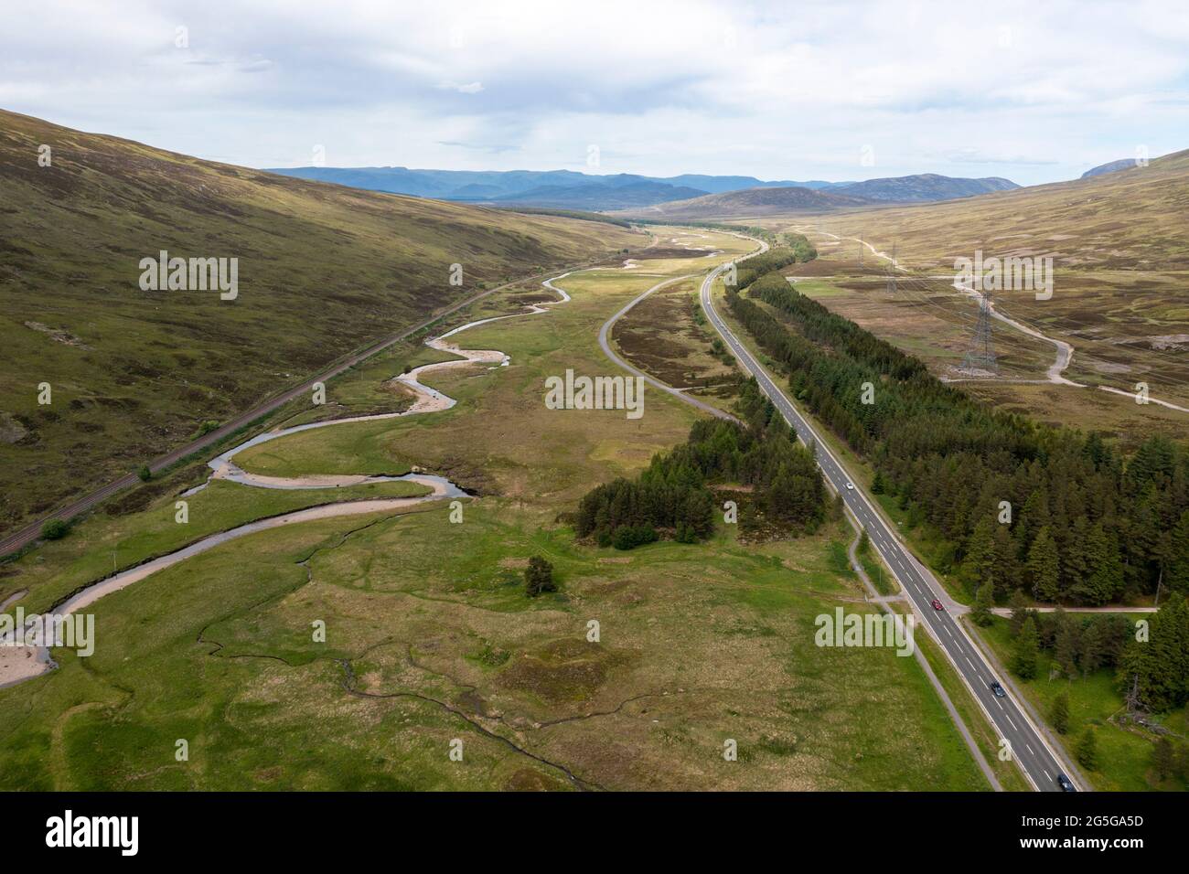 Vista aérea de la carretera principal A9 y la línea principal de ferrocarril de las tierras altas en el Puerto de Drumochter, región de Highland, Escocia, Reino Unido Foto de stock