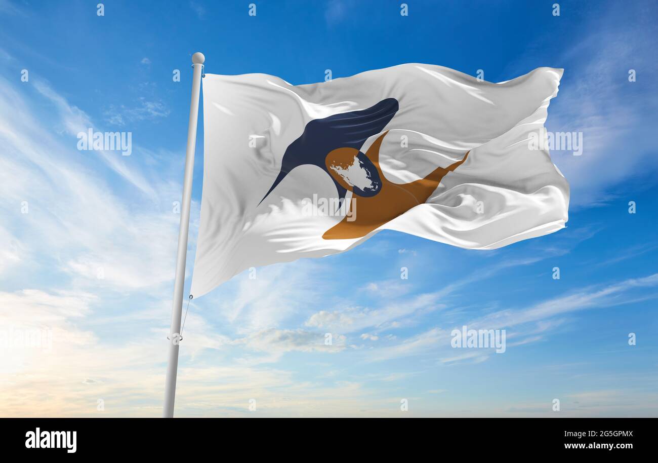 Minsk, Bielorrusia - Mayo, 2021: Bandera de la Unión Económica Eurasiática ondeando en el viento al asta de la bandera sobre el fondo del cielo azul. ilustración 3d. Foto de stock